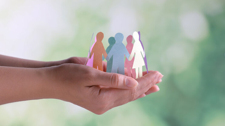 ISO 45001 - Arbeits- und Gesundheitsschutzmanagementsystem Nahaufnahme von Händen, die menschliche Papierfiguren halten, vor einem verschwommenen Hintergrund. Dieses Bild veranschaulicht das Konzept von Diversität und Inklusion. In der Geschäftsethik von weba Werkzeugbau symbolisiert dieses Bild die Richtlinie zur Warhung der Menschenrechte und Einhaltung arbeitsrechtlicher Vorschriften.