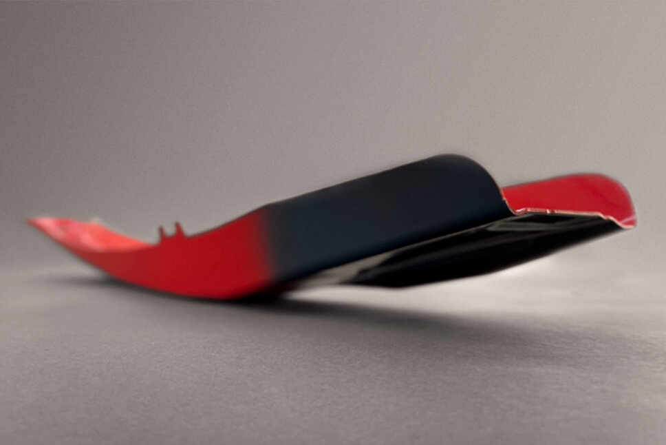 Aufnahme einer rotlackierten warmumgeformten B-Säule eines Fahrzeugs, wobei die SoftZone in Anthrazitgrau dargestellt wird. Das Produkt wurde in der Serienfertigung bei weba Werkzeugbau produziert.  