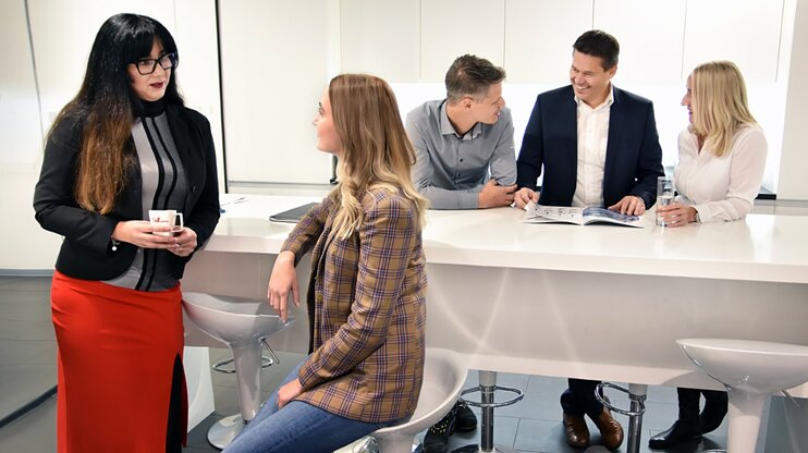 Angestellte der weba Werkzeugbau stehen in der Kaffeeküche und unterhalten sich.