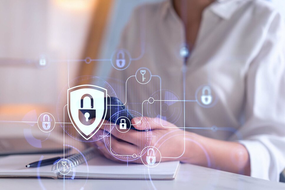 Eine Frau hält ein Handy in der Hand, über dessen Foto verschiedene Sicherheitssymbole eingeblendet sind, was den Fokus auf Sicherheit und Technologie legt. In der Geschäftsethik von weba Werkzeugbau symbolisiert dieses Bild den Datenschutz und Umfang mit Informationen.