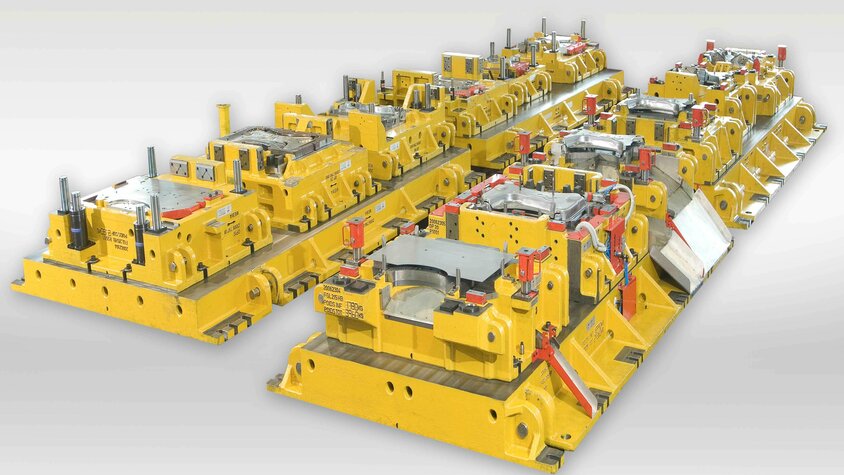Transferwerkzeugsatz für die Kaltumformung: Mehrere hintereinandergeschaltete Werkzeugstationen zur Umformung komplexer Blechbauteile in der Automobilproduktion.