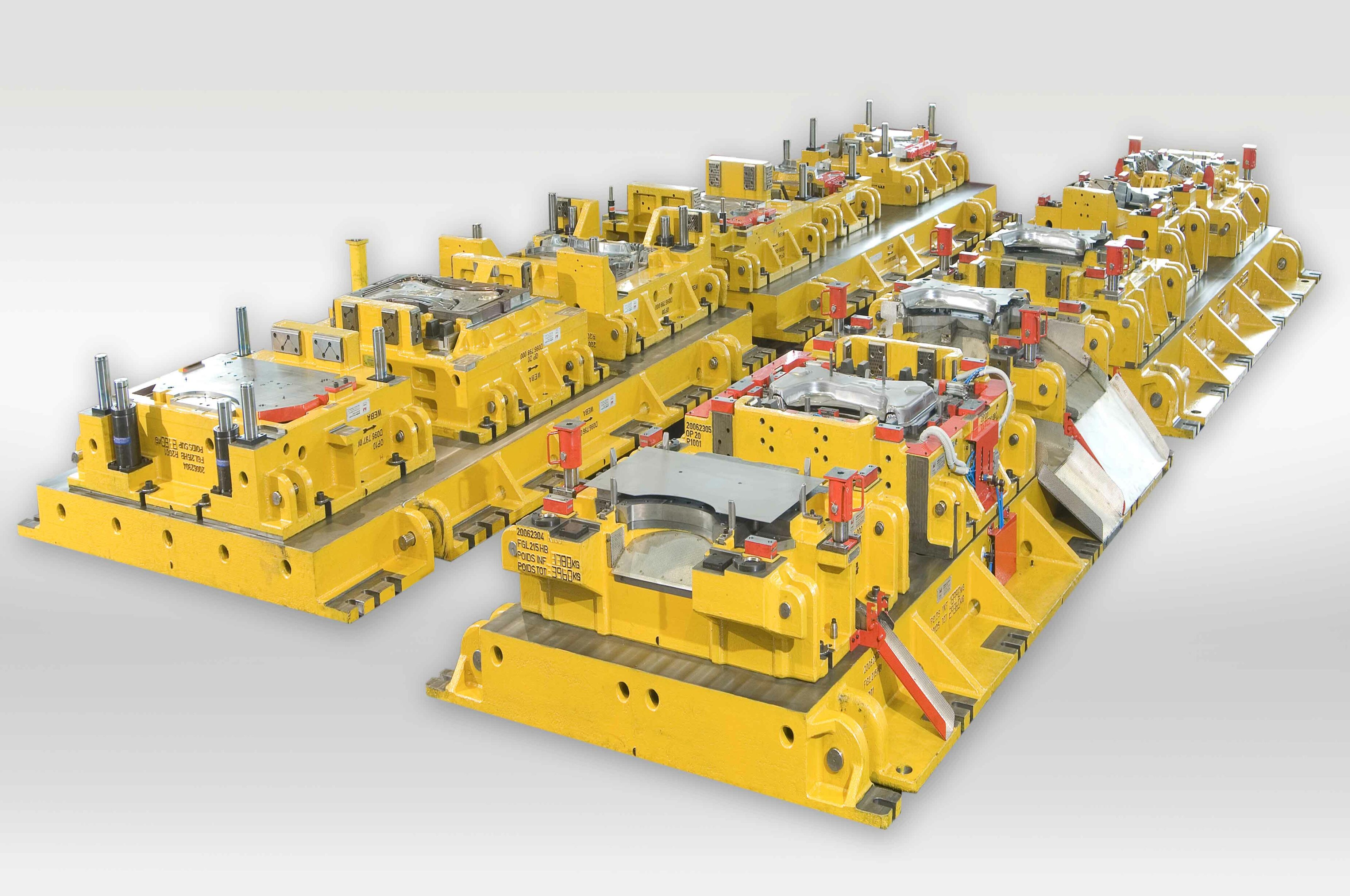 Transferwerkzeugsatz für die Kaltumformung: Mehrere hintereinandergeschaltete Werkzeugstationen zur Umformung komplexer Blechbauteile in der Automobilproduktion.