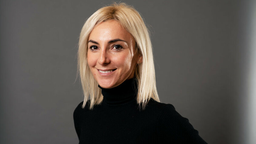  Porträt von Ivana Vujica, strategische Einkäuferin bei weba, vor einem grauen Hintergrund.