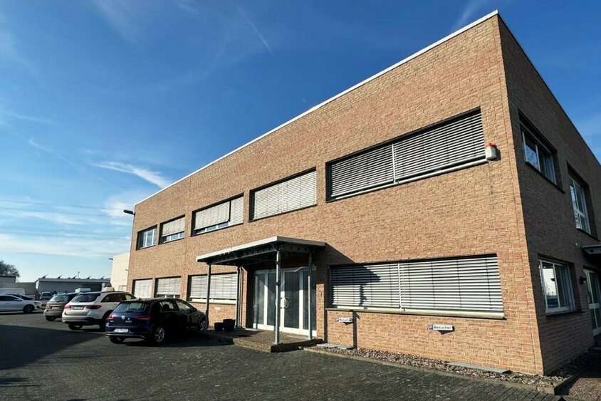 Das Firmengebäude der weba Deutschland GmbH, einem Experten für Prototypenbau, bei sonnigem Wetter mit Parkplätzen und moderner Architektur.