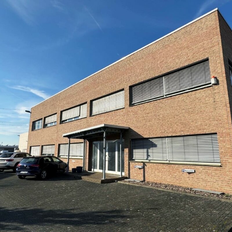 Das Firmengebäude der weba Deutschland GmbH, einem Experten für Prototypenbau, bei sonnigem Wetter mit Parkplätzen und moderner Architektur.