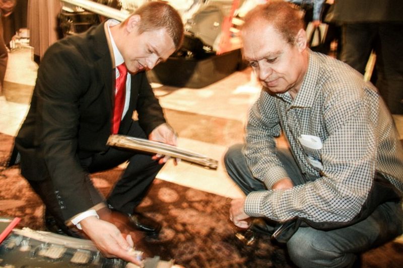 Vertriebsleiter von weba erklärt einem Besucher die Funktionalität des Miniatur-Warmumformwerkzeuges