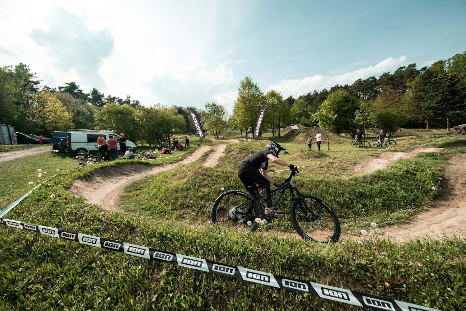 Radek Šimek fährt mit Helm und Mountainbike über eine kurvige Dirt-Strecke beim Training.