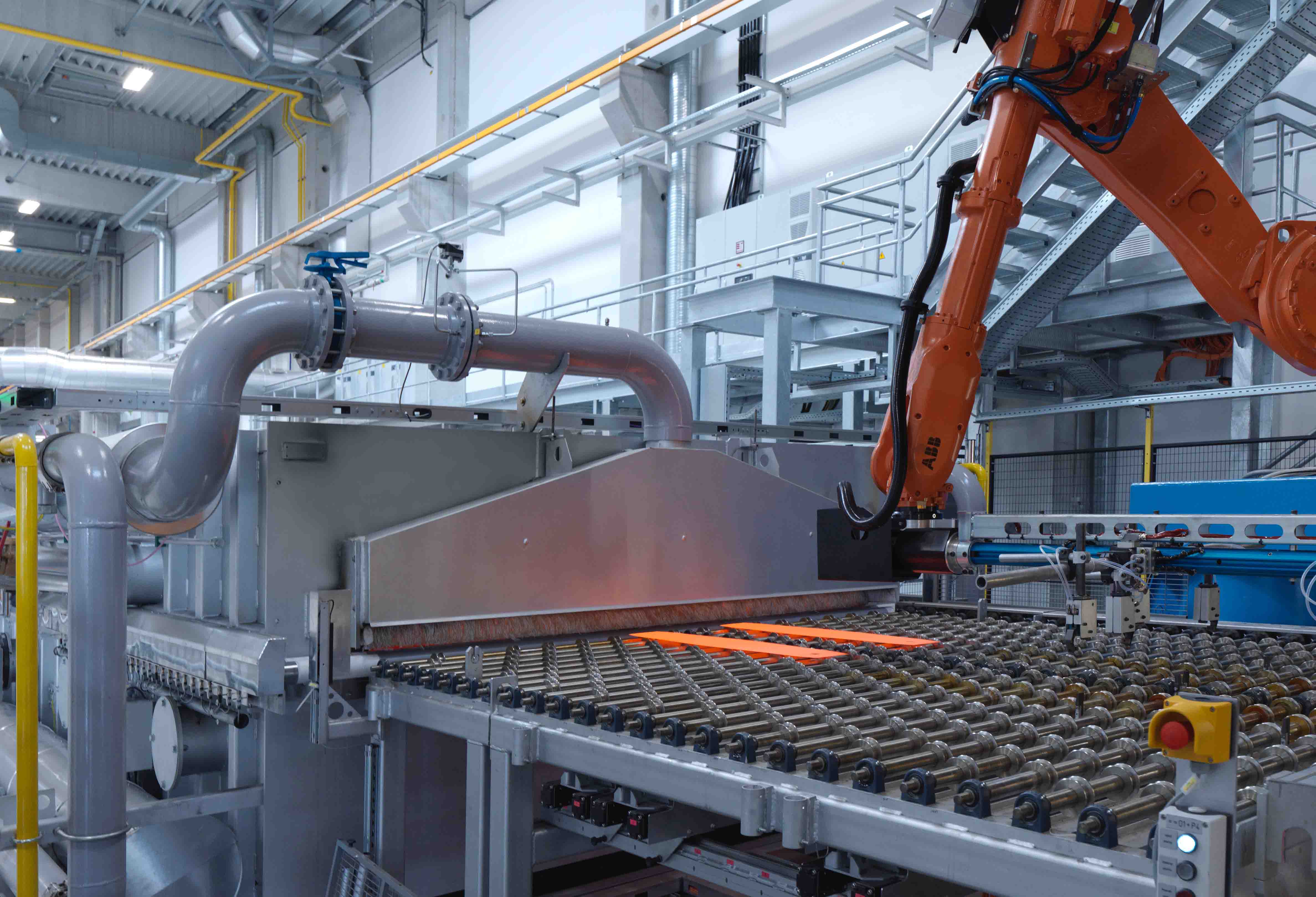 Automated hot forming system with robotic handling and a glowing steel sheet for the production of high-strength lightweight components.